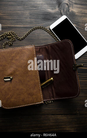 Contents of woman's bag on wooden background, from above Stock Photo