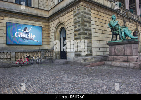 Seated statue of Adam Oehlenschlager and electronic advertising display board outside the Royal Danish Theatre (Kongelige Teater), Copenhagen, Denmark Stock Photo