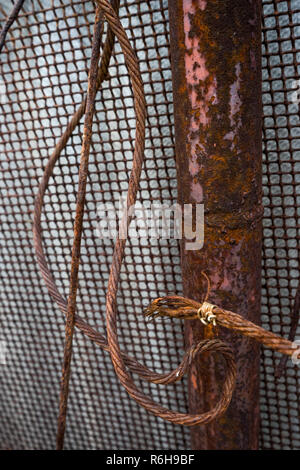 old rusty fence with pipe, mesh and wire Stock Photo