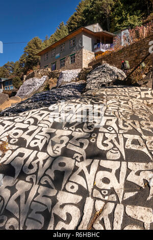 Nepal, Benkar, huge painted, carved Buddhist mani stone on Everest Base Camp Trek path Stock Photo
