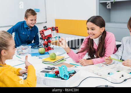 happy schoolchildren working on robot at STEM robotics lesson Stock Photo