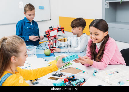 happy schoolchildren working on robot at STEM robotics lesson Stock Photo