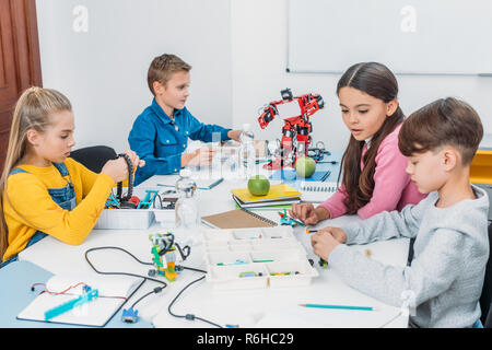 attentive schoolchildren working on robot at STEM robotics lesson Stock Photo
