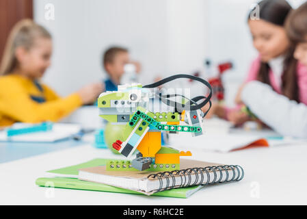 selective focus of handmade robot model and classmates working together on project during STEM lesson on background Stock Photo