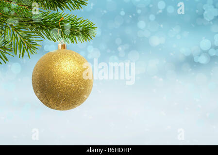 Christmas golden color ball hung on the Christmas tree. Free space beside for Christmas greeting text. Stock Photo