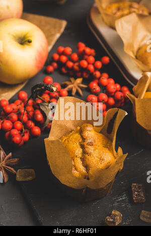 Muffins with pumpkin and apples on the rustic background with autumn decorations. Selective focus. Stock Photo