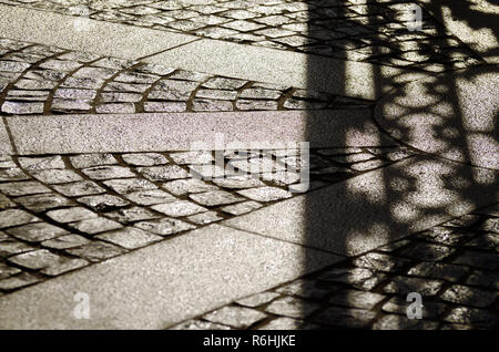 bright sunny day.The contrasting shadow on the pavement from the wrought-iron gate. Stock Photo