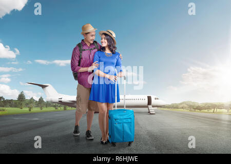 Young asian tourist couple with luggage going traveling with airplane Stock Photo