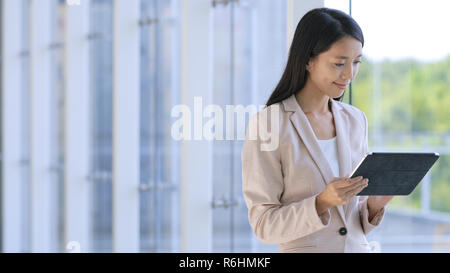 Professional Business woman looking at tablet computer in corporate building Stock Photo