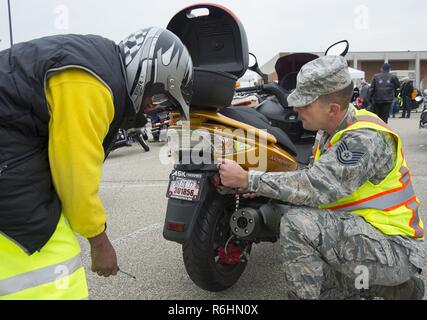 Tech. Sgt. Timothy Noel, 88th Air Base Wing Safety Office, helps Bernard White with the license plate for his new motorcycle prior to the start of the annual Motorcycle Safety Day ride at Wright-Patterson Air Force Base, Ohio, May 12, 2017. The safety day gave Wright-Patt riders the opportunity to network with other riders. Stock Photo