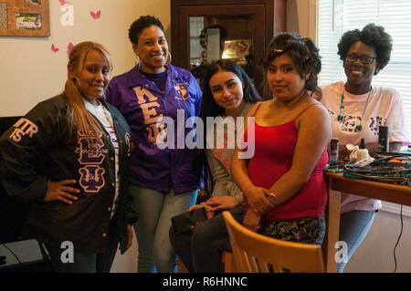 (Form left to right) Sgt. 1st Class Ericka Parker, Spc. Natasha Manning-Redmond and Staff Sgt. Phylicia Rolland, military sorority sisters pause for a group photo with Samantha Aguilar and Erin Flores, seniors from Clover Park High School May 13, 2017, on Joint Base Lewis-McChord, Washington. A total of four students received assistance from the sorority sisters that included hair and makeup, shoes, and spa treatments in preparation for the senior prom. Stock Photo