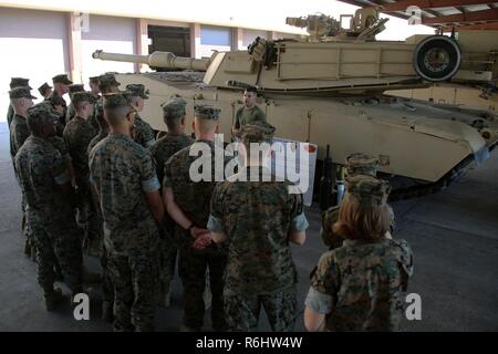 Staff Sgt. Cody Ferrell gives a class about the M1A1 Abrams tank during a field trip at Marine Corps Base Camp Lejeune N.C., May 16, 2017. Marines assigned to the Marine Corps Air Station Cherry Point Squadron Intelligence Training Certification Course had the opportunity to visit various units stationed at MCB Camp Lejeune, N.C. and MCAS New River, N.C., in order to provide them a better understanding about capabilities and limitations of aircraft, weapons systems and vehicles their units may utilize. Ferrell is an M1A1 tank crewman assigned to 2nd Tank Battalion, 2nd Marine Division. Stock Photo