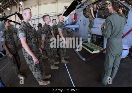 Capt. Victoria Ross gives a class about the AH-1W Super Cobra during a field trip at Marine Corps Air Station New River, N.C., May 16, 2017. Marines assigned to the Marine Corps Air Station Cherry Point Squadron Intelligence Training Certification Course had the opportunity to visit various units stationed at MCB Camp Lejeune, N.C. and MCAS New River, N.C., in order to provide them a better understanding about capabilities and limitations of aircraft, weapons systems and vehicles their units may utilize. Ross is a pilot assigned to Marine Light Attack Helicopter Squadron 269, Marine Aircraft G Stock Photo