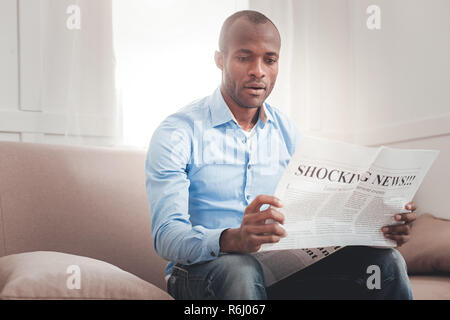 Nice serious man sitting on the sofa Stock Photo