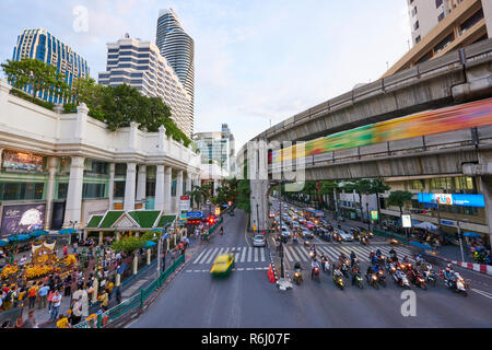 High angle shot of Ratchaprasong Intersection and Erawan Shrine in Bangkok, Thailand, with motion blurred cars driving past in busy traffic. Stock Photo