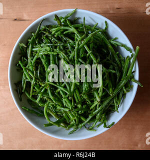 Salicornia (aka sea asparagus, samphire, glasswort, or pickleweed) - a salty edible halophilic plant eaten as a unique vegetable. Stock Photo