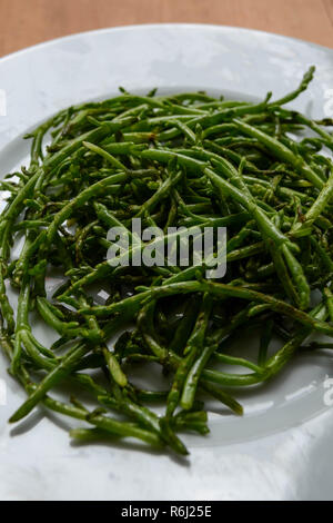 Salicornia (aka sea asparagus, samphire, glasswort, or pickleweed) - a salty edible halophilic plant eaten as a unique vegetable. Stock Photo