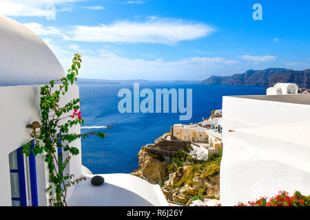 View of the Aegean Sea and caldera as a boat crosses, from the cliffside city of Oia, Greece, on the Cyclades island of Santorini Stock Photo