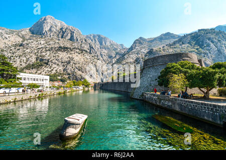 The medieval city walls and moat separating old and new town, with the mountains behind in the Adriatic ancient city of Kotor, Montenegro. Stock Photo
