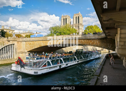 PARIS - September 08: People ride on a pleasure boat on the river Seine in Paris, France on September 08, 2013.  Paris is the most visited city in the Stock Photo