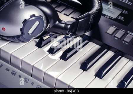 Headphones lying on top of a synthesizer Stock Photo