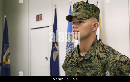 Cpl. David Qualls, a motor transport assistant operations chief with Marine Wing Support Squadron 471, 4th Marine Aircraft Wing, Marine Forces Reserve, stands at parade rest while he waits to be awarded the Navy and Marine Corps Medal at the 1st Battalion, 23rd Marine Regiment headquarters in Houston, Texas, May 20, 2017. In 2014, helped save a man stuck inside a burning vehicle. According to Qualls’ award summary, had he not arrived when he did, the man would have surely died. Stock Photo