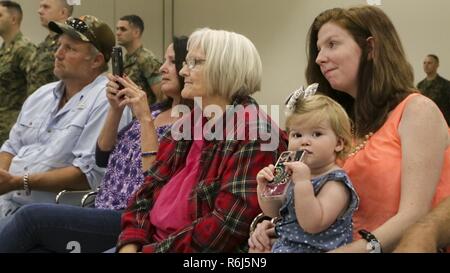 The family of Cpl. David Qualls, a motor transport assistant operations chief with Marine Wing Support Squadron 471, 4th Marine Aircraft Wing, Marine Forces Reserve, listen attentively as Qualls receives his Navy and Marine Corps Medal at the 1st Battalion, 23rd Marine Regiment headquarters in Houston, Texas, May 20, 2017. In 2014, Qualls and other Marines helped save a man stuck inside a burning vehicle. According to the award summary, had he not arrived when he did, the man would have surely died. Stock Photo