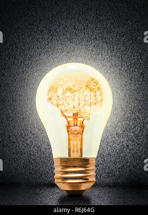 Anatomy of a human brain glowing inside illuminated light bulb with concrete background and copy space. Concept of bright idea, brainstorming, intelli Stock Photo