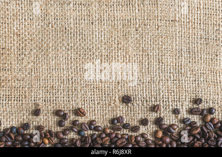 Roasted Coffee Beans on Burlap Background. Copy Space for Text. Stock Photo