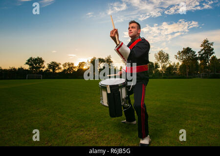 Percussion player or drummer during an outdoor photo shoot with studio lamps in an attractive interactive evening scene Stock Photo