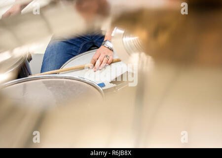 Drummer playing on drum set top view. Live music concert, band during performance. View and look through allong cymballs on snare drum and drum sticks Stock Photo