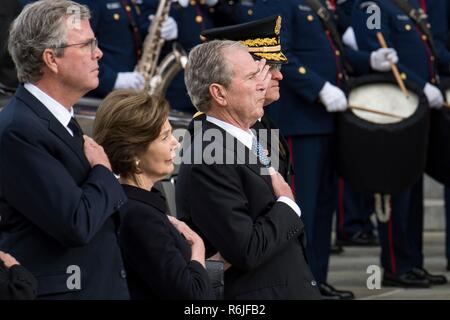 Former President George W. Bush, center, First Lady Laura Bush and former Florida Gov. Jeb Bush salute their father as pallbearers carry the flag-draped casket of former president George H.W. Bush to the awaiting hearse following the State Funeral at at the National Cathedral December 5, 2018 in Washington, DC. Bush, the 41st President, died in his Houston home at age 94. Stock Photo