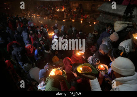 Kathmandu, Nepal. 6th Dec 2018. Nepalese devotees lights oil lamps in memory of deceased family members during Bala Chaturdashi festival at the Pashupatinath temple.   Bala Chaturdashi is celebrated in memory of departed family members by lighting oil lamps and scattering seven types of grains known as 'SATSIJ' along a prescribed route. Credit: SOPA Images Limited/Alamy Live News Stock Photo