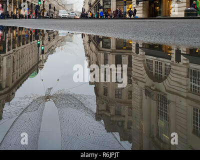 Regent Street, London, UK. 5th Dec, 2018. Reflection of Christmas Lights on Regent Street are seen in a large puddle of water following rainfall in London. Credit: Dinendra Haria/Alamy Live News Stock Photo