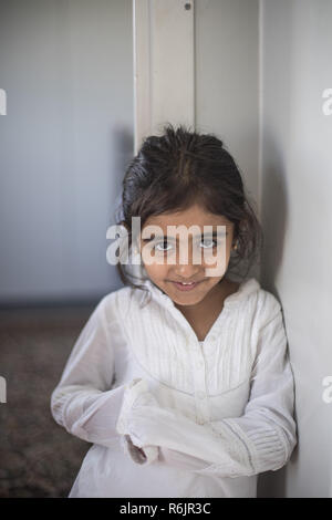 November 2, 2018 - Thessaloniki, Greece - A young girl seen posing for a photo at the Diavata Refugee Camp in Thessaloniki..A refugee family with Kurdish origins from Iraq and Syria are seen in their prefabricated house in Diavata Refugee Camp in Thessaloniki, Greece. The family members are the mother, father, 2 girl and a boy along with the elders and they are waiting for their asylum application decision from EASO. (Credit Image: © Nicolas Economou/SOPA Images via ZUMA Wire) Stock Photo