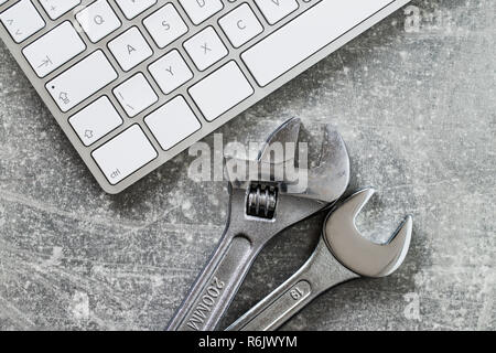 Wrench and computer keyboard. Metallic spanner. Stock Photo
