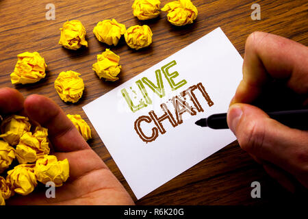 Word, writing Live Chat . Concept for Communication Livechat written on notebook note paper on the wooden background with folded paper meaning thinking for idea. Man hand and marker. Stock Photo