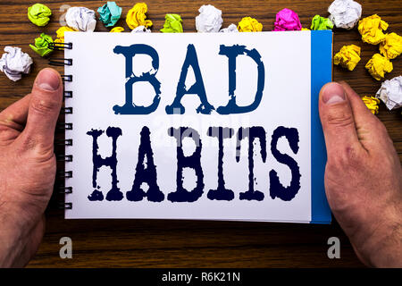 Writing text showing Bad Habits. Business concept for Improvement Break Habitual Hebit written on notepad notebook book on the wooden wood background with man businessman hand and finger. Stock Photo