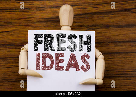 Conceptual hand writing text caption inspiration showing Fresh Ideas. Business concept for Thinking Inspiration Inspire Creativity written on sticky note paper on the wooden background. Holding by the sculpture. Stock Photo