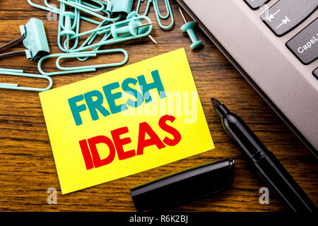 Handwriting Announcement text showing Fresh Ideas. Business concept for Thinking Inspiration Inspire Creativity written on sticky note paper on the wooden background next to the laptop keyboard With marker Stock Photo