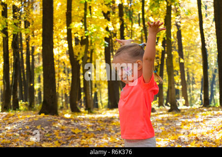 Little happy girl playing in autumn park Stock Photo