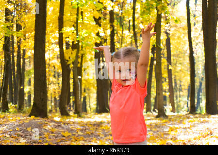 Happy little girl playing in autumn park Stock Photo