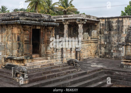 Belur, Karnataka, India - November 2, 2013: Chennakeshava Temple. Brown stone dilapidated shrine in corner of the grounds adjacent to water tank. Dark Stock Photo