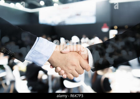 Deal or agreement business concept, handshake double exposure, coperation or partnership business with seminar conference meeting in background. Stock Photo