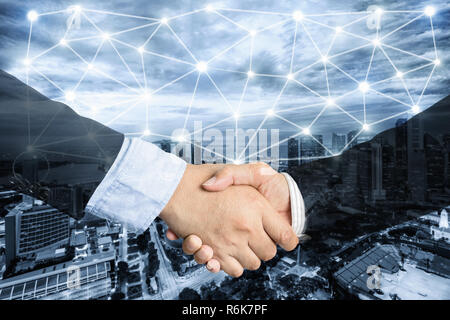 Deal or agreement business concept, handshake double exposure, coperation or partnership business with network connection. Stock Photo