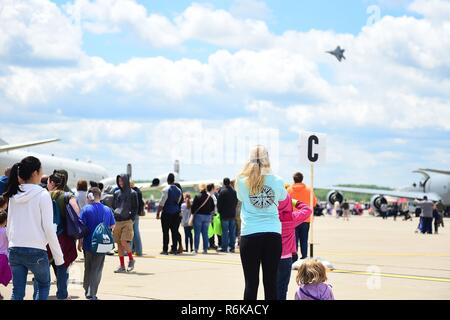 Spectators watch an F-22 Raptor demonstration during the 911th Airlift Wing's Wings Over Pittsburgh 2017 Air Show, at Coraopolis, Pa., May 13, 2017. Throughout the show, spectators also watched performances by the U.S. Air Force Blue Thunderbirds and many other aircraft. Stock Photo