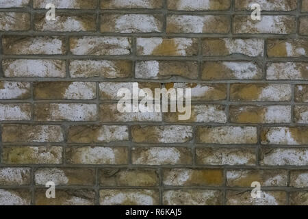 macro closeup of a yellow stone brick wall with white blotches, a architecture background. Stock Photo