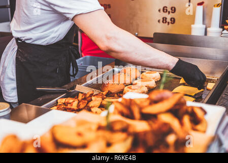 Cooking burger in the city street cafe. Process of fast food cooking Stock Photo