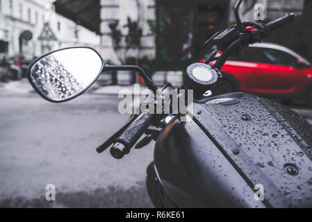 Black motorbike parked on city street. Selective color photo Stock Photo