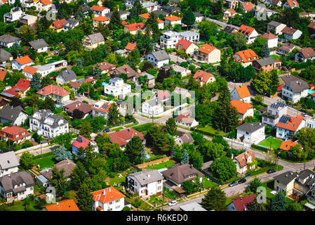 Suburban neighborhood with modern living residential houses. Ecologically clean places for living. Solar batteries on the roofs. Suburban infrastructu Stock Photo